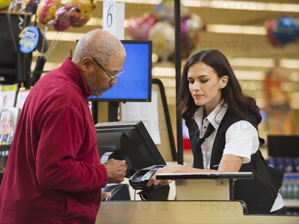 Cashier and customer at grocery store checkout