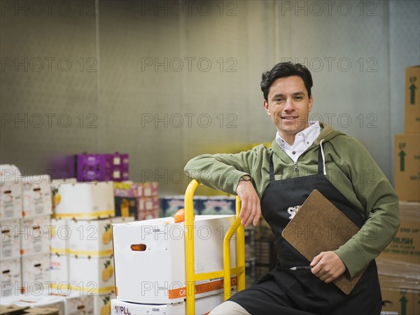 Hispanic worker carting boxes in walk-in freezer