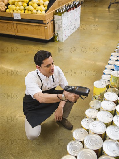 Hispanic worker scanning items in grocery store