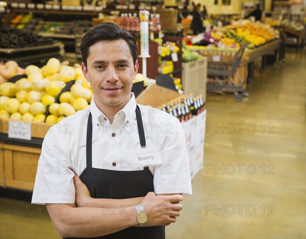 Hispanic worker smiling in grocery store