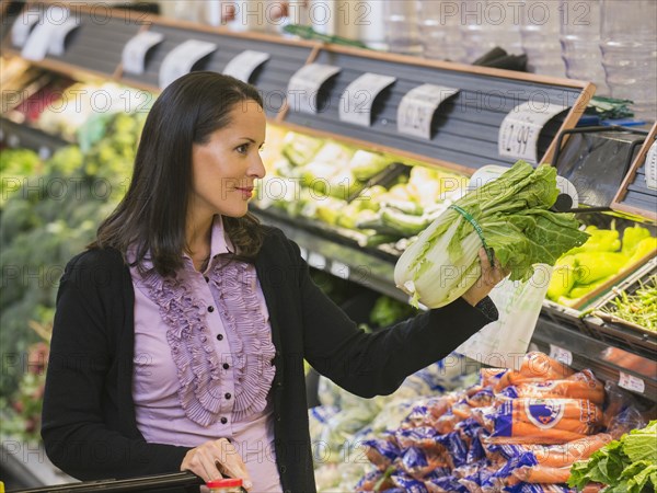 Hispanic woman shopping for produce in grocery store