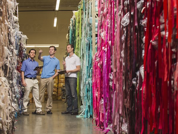 Workers examining fabric in textile factory