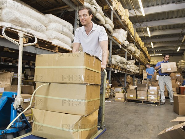 Worker stacking boxes in textile factory