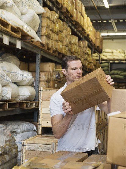 Caucasian worker stacking boxes in textile factory