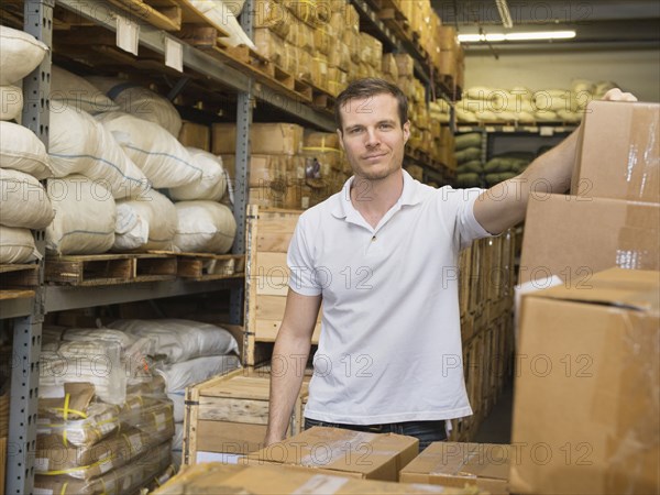 Caucasian worker stacking boxes in textile factory