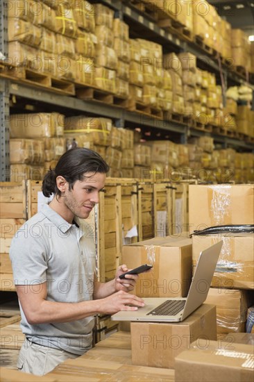 Mixed race worker using laptop in textile factory