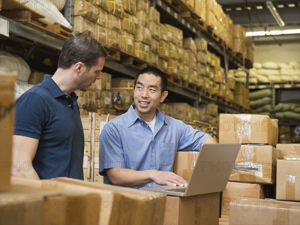 Workers using laptop in textile factory