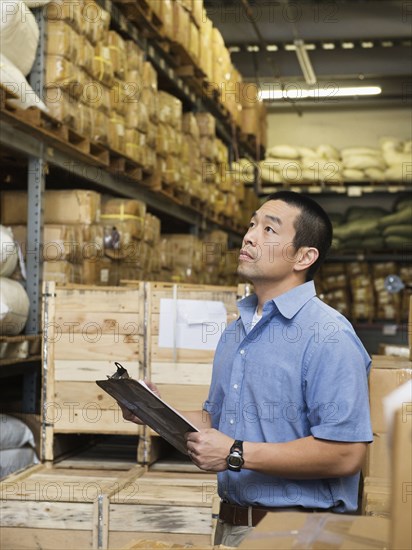 Chinese worker using clipboard in textile factory