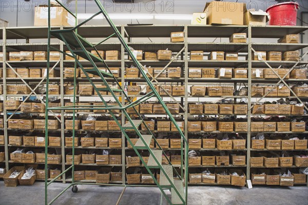 Rolling stairs by shelves in textile factory