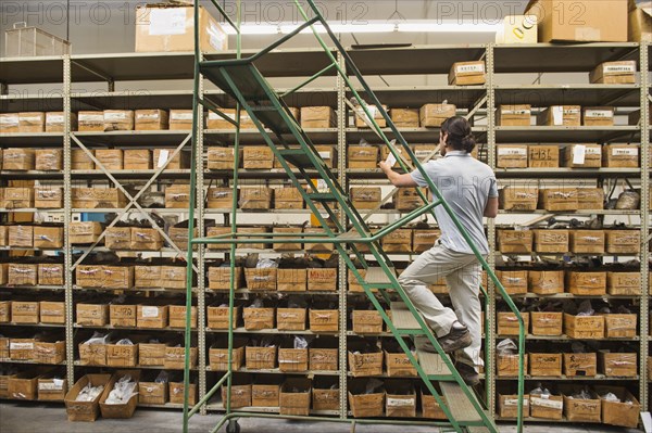 Mixed race worker examining boxes in textile factory