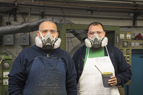 Hispanic workers wearing gas masks in textile factory