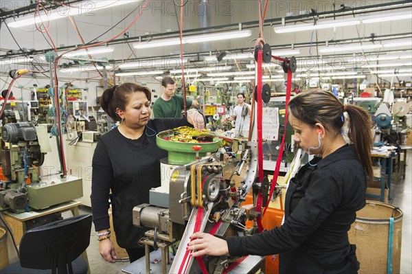 Workers operating machinery in textile factory