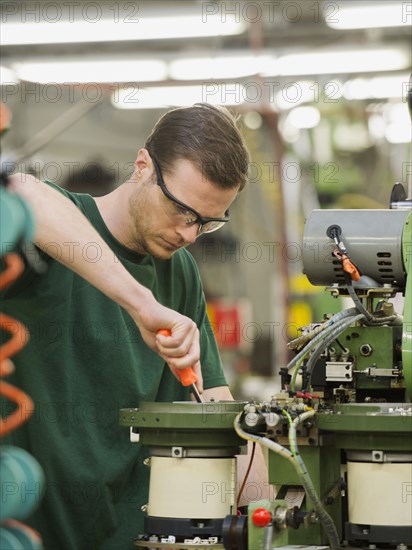 Caucasian worker operating machinery in textile factory