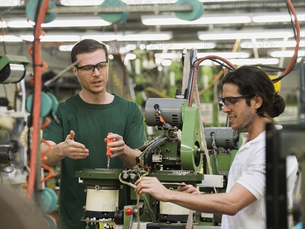 Workers operating machinery in textile factory