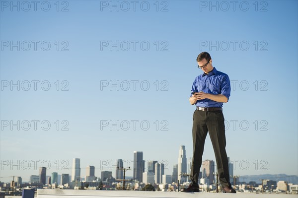 Caucasian businessman standing on urban rooftop