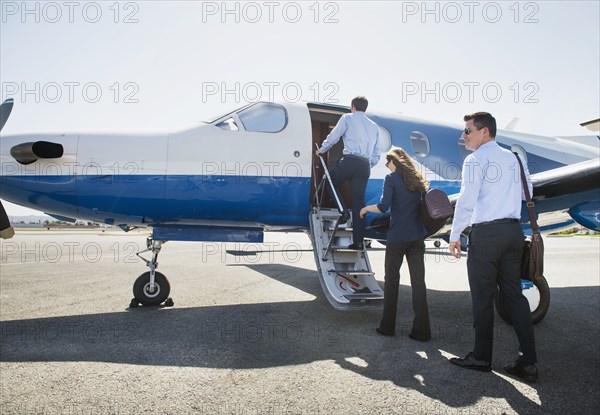 Business people boarding airplane on runway
