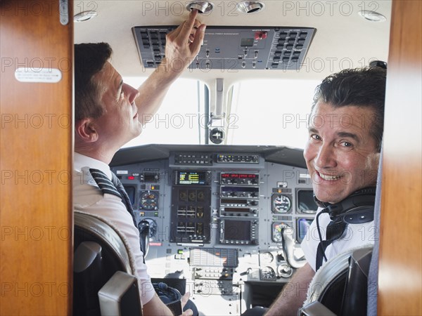 Caucasian pilots in airplane cockpit