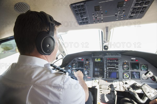 Caucasian pilot working in airplane cockpit