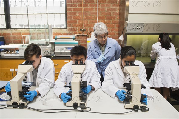 Teacher and students working in science lab