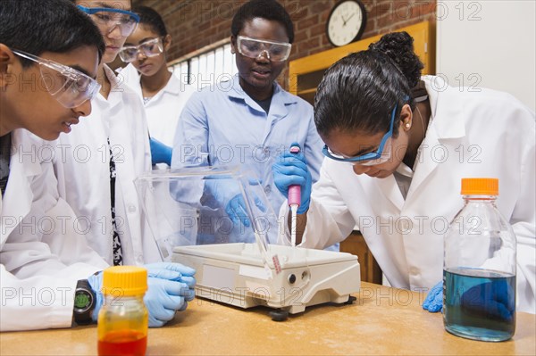 Teacher and students working in science lab