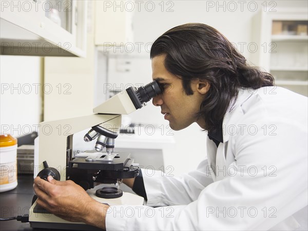 Indian scientist using microscope in laboratory