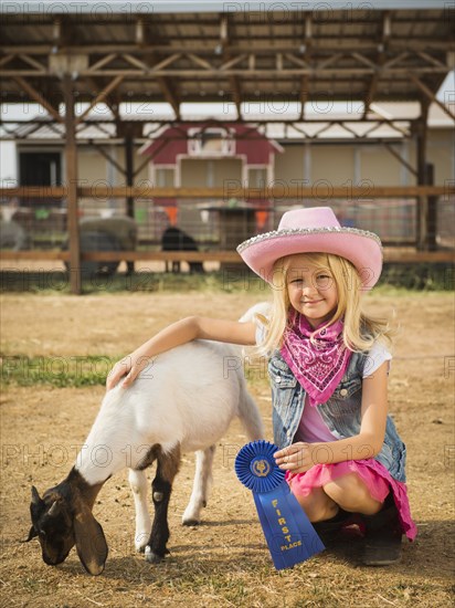 Caucasian girl with prize winning goat on farm