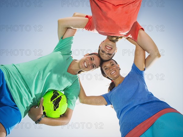 Caucasian women smiling in huddle under blue sky