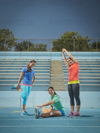 Caucasian women stretching on running track