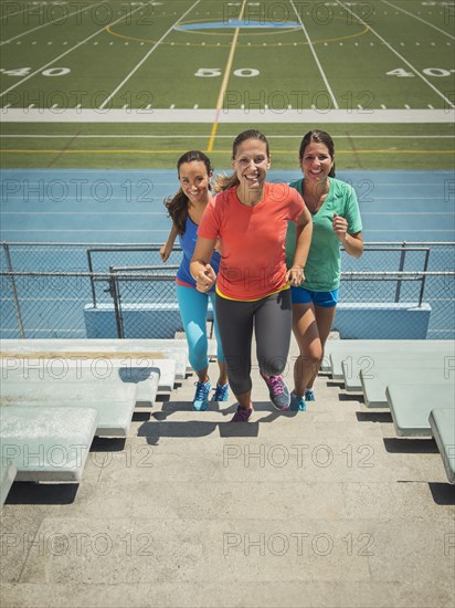 Caucasian women running on bleacher steps