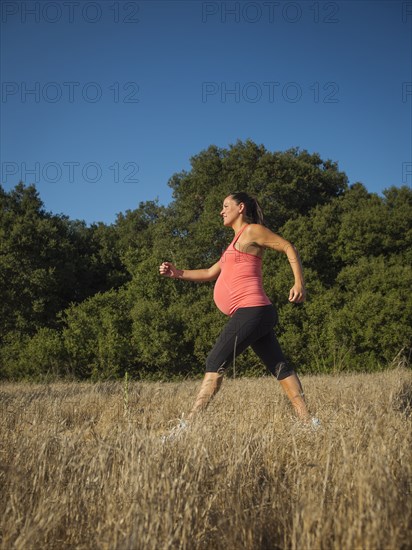 Pregnant Hispanic woman walking outdoors