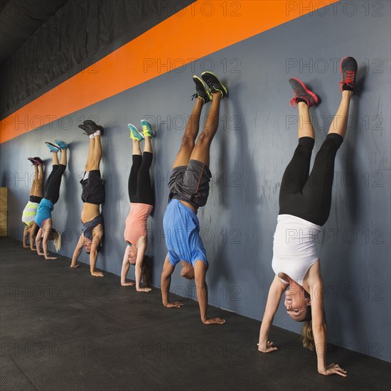 People doing handstands together in gym