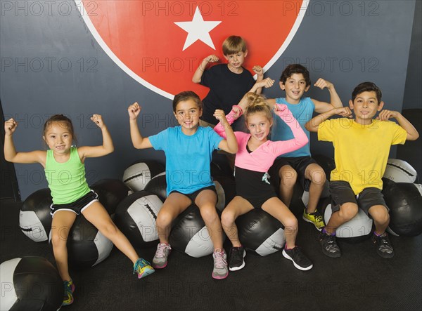 Children flexing their muscles in gym