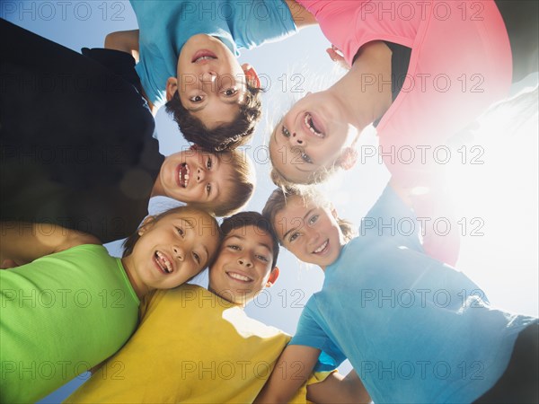 Children smiling in circle outdoors