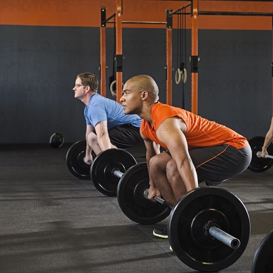 Men lifting weights in gym