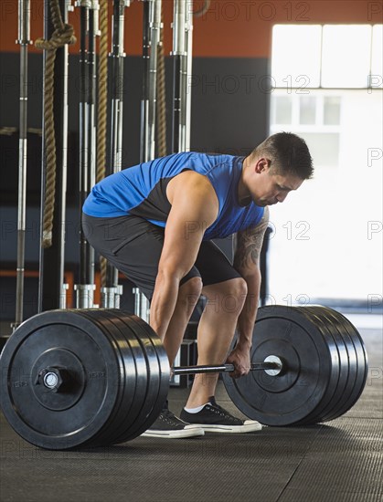 Caucasian man lifting weights in gym