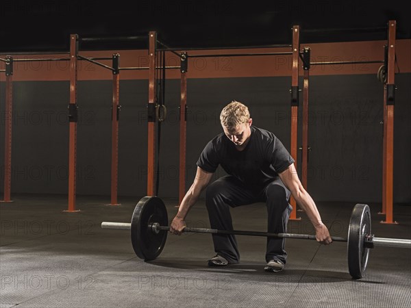 Caucasian man lifting weights in gym