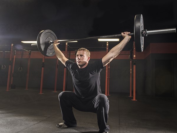 Caucasian man lifting weights in gym