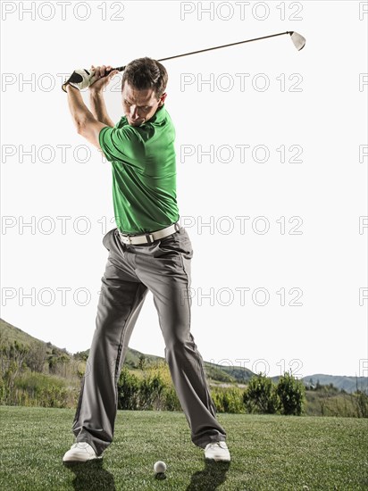 Caucasian man playing golf on course