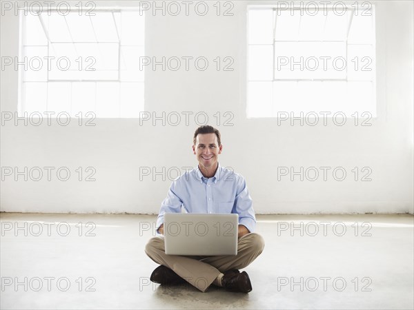 Caucasian businessman using laptop in empty office