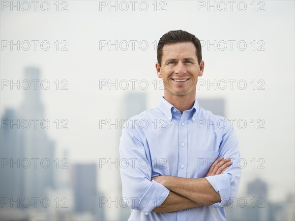 Caucasian businessman standing on urban rooftop