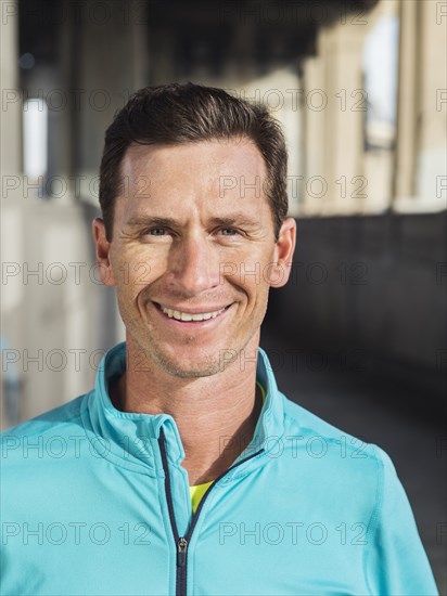 Caucasian man smiling in urban tunnel