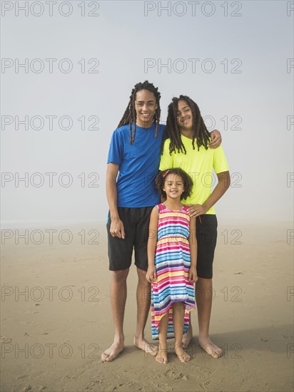 Black siblings smiling on beach