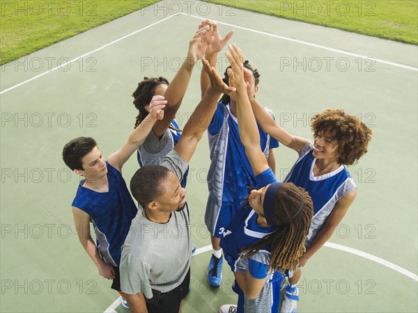 Basketball team high fiving on court