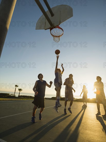 Back lit basketball teams playing on court