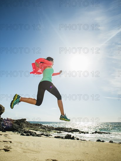 Caucasian woman running on beach