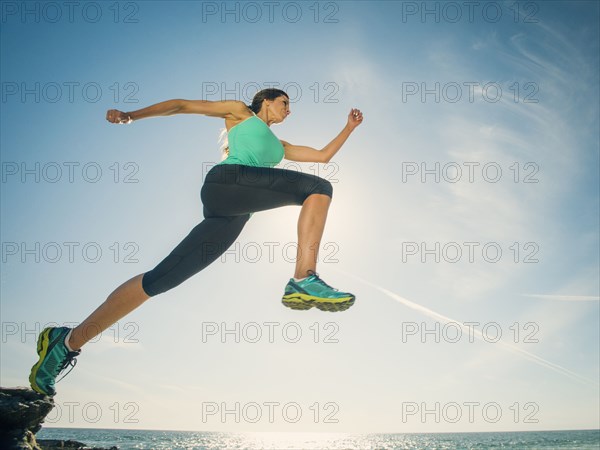 Caucasian woman running on beach