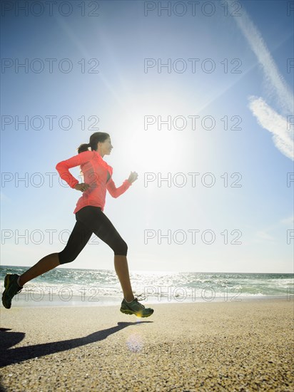 Caucasian woman running on beach