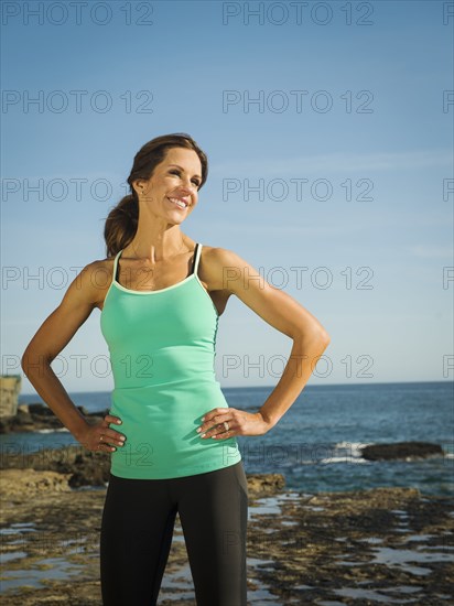 Caucasian runner smiling on beach