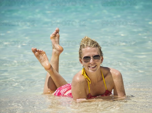 Caucasian woman laying in water in tropical ocean