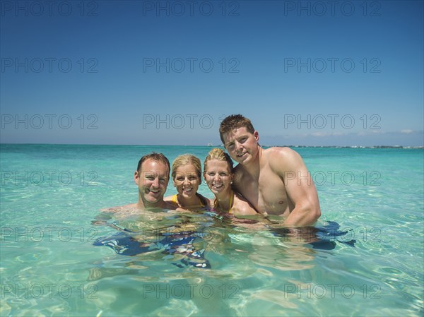 Caucasian couples smiling together in tropical ocean